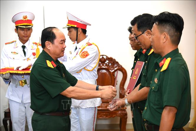 Đại tá Nguyễn Văn Ngành, Chỉ huy trưởng Bộ CHQS tỉnh An Giang trao quyết định cho các cán bộ, sĩ quan, quân nhân chuyên nghiệp. Ảnh: Văn Sĩ - TTXVN