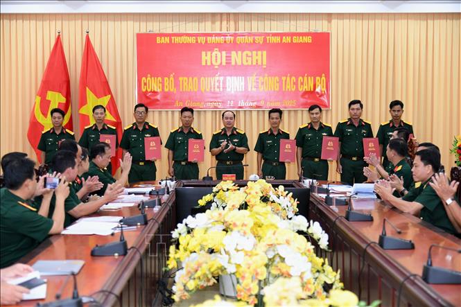 Đại tá Nguyễn Văn Ngành, Chỉ huy trưởng Bộ CHQS tỉnh An Giang trao quyết định cho các cán bộ, sĩ quan, quân nhân chuyên nghiệp. Ảnh: Văn Sĩ - TTXVN