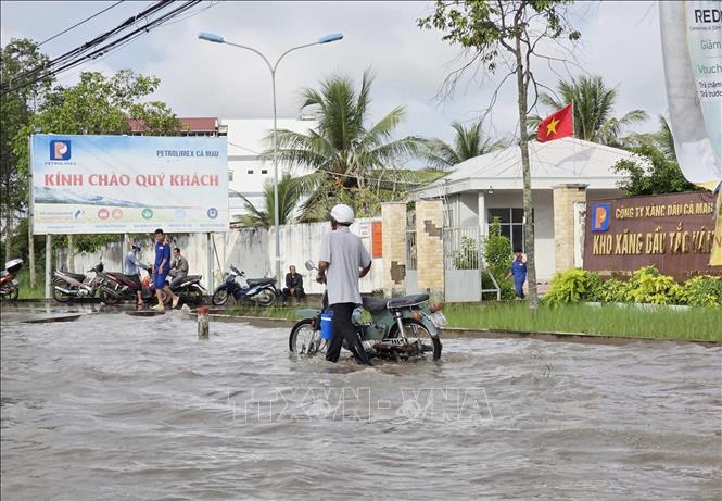 Nhiều xe máy phải dắt bộ do nước ngập sâu gây chết máy. Ảnh: Chanh Đa-TTXVN