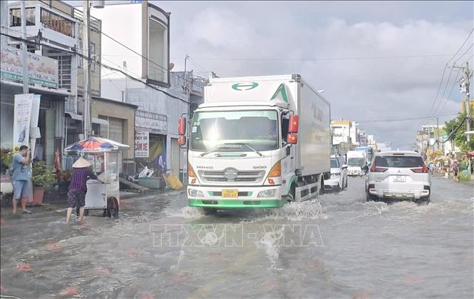  Các phương tiện giao thông di chuyển chậm trên tuyến đường ngập sâu. Ảnh: Chanh Đa-TTXVN