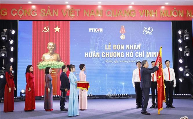 Tổng Bí thư Tô Lâm gắn Huân chương Hồ Chí Minh lên lá cờ truyền thống Thông tấn xã Việt Nam. Ảnh: Doãn Tấn - TTXVN