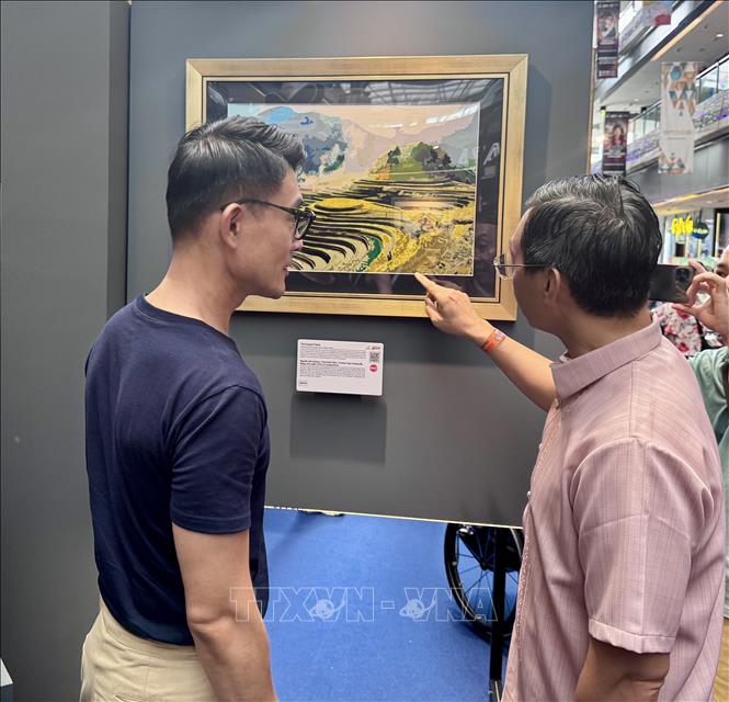 Đại sứ Trần Phước Anh (phải) giới thiệu tranh của Việt Nam với ông Baey Yam Keng-Quận trưởng Quận Đông Bắc. Ảnh: Đỗ Vân- PV TTXVN tại Singapore