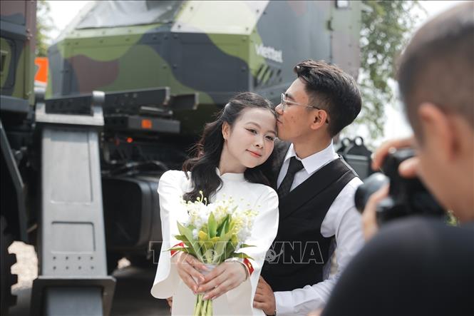 Đôi bạn trẻ lưu lại khoảnh khắc ảnh cưới tại Triển lãm Thành tựu đất nước. Ảnh: Minh Quyết - TTXVN