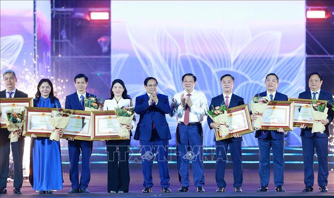Thủ tướng Phạm Minh Chính tặng bằng khen cho tập thể, cá nhân có thành tích xuất sắc trong tổ chức và thực hiện triển lãm. Ảnh: Dương Giang-TTXVN
