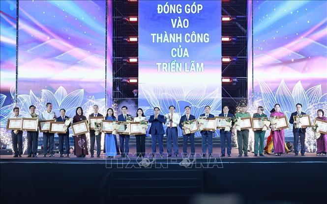 Thủ tướng Phạm Minh Chính tặng bằng khen cho tập thể, cá nhân có thành tích xuất sắc trong tổ chức và thực hiện triển lãm. Ảnh: Dương Giang-TTXVN
