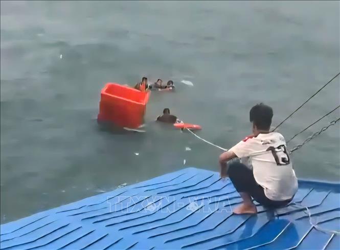 Thủy thủ và thuyền viên cứu ngư dân gặp nạn trên biển. Ảnh: TTXVN phát