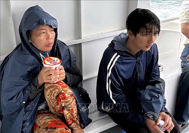 Bà Nguyễn Thị Kim Nhật và con trai Cao Văn Sáng sau khi được thủy thủ, thuyền viên cứu đưa lên tàu. Ảnh: TTXVN phát