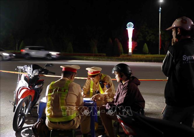 Lực lượng chức năng lập biên bản xử lý phụ nữ điều khiển xe mô tô BKS 19F1-407.xx vi phạm nồng độ cồn ở mức 0,097mg/lít khí thở. Ảnh: Quý Trung – TTXVN