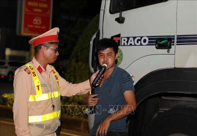 Tổ công tác Đội cảnh sát giao thông đường bộ số 1 kiểm tra nồng độ cồn người vi phạm có ý định bỏ trốn. Ảnh: Quý Trung – TTXVN