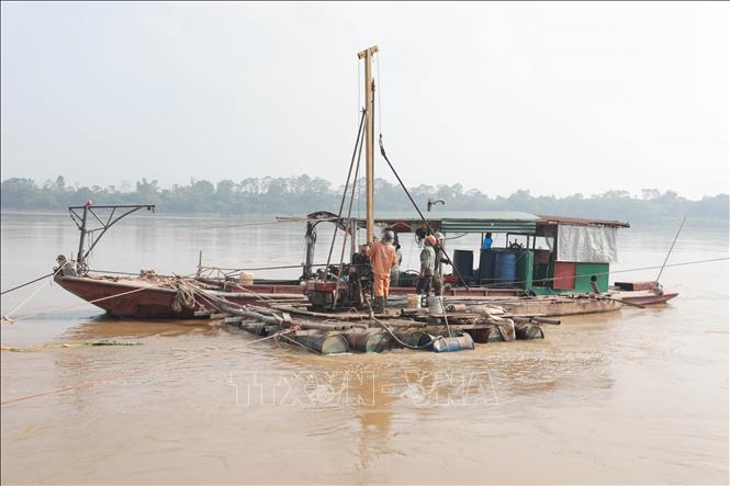 Các đơn vị liên quan đang thăm dò địa chất phía bên ngoài kè để xử lý chân kè. Ảnh: Tạ Toàn – TTXVN