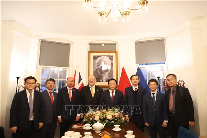 Ủy viên Bộ Chính trị Nguyễn Xuân Thắng và đoàn cán bộ Học viện Chính trị Quốc gia Hồ Chí Minh chụp ảnh lưu niệm với ông Hugh Morris. Ảnh Hữu Tiến - PV TTXVN tại Anh
