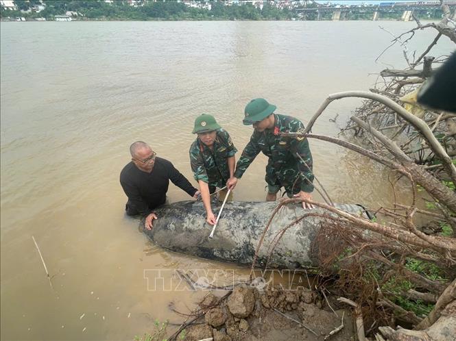 Sappers measure the bomb's size. VNA Photo/Photo by courtesy