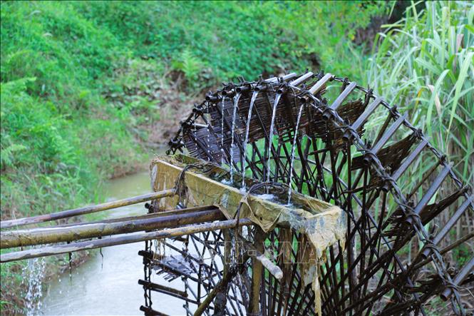 Nước được bánh xe của cọn nước múc từ suối lên đổ vào máng gom nước để đổ về ruộng đồng theo hệ thống đường dẫn được đặt trên vị trí cao của cọn nước. Ảnh: Xuân Tiến - TTXVN 