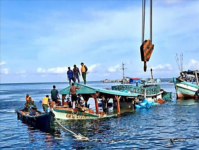 Tàu cá CM 91554 TS bị nạn trên biển được các lực lượng và nhân dân hỗ trợ lai dắt vào bờ. Ảnh: TTXVN phát