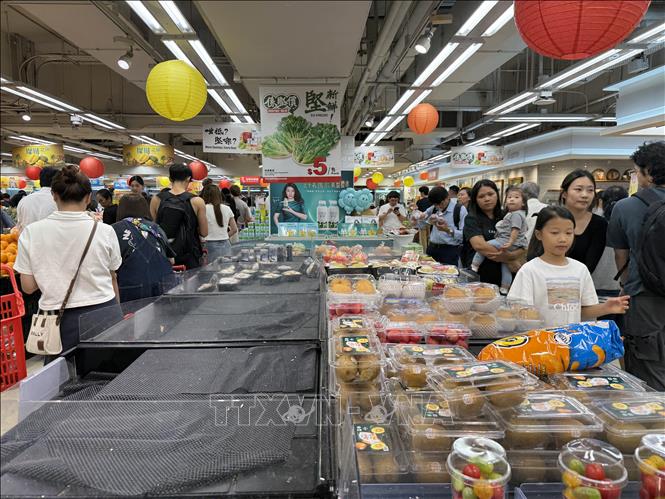 Người dân Hong Kong đổ xô đi siêu thị tích trữ đồ ăn phòng bão Ragasa, tối 22/9. Ảnh: Mạc Luyện - PV TTXVN tại Hong Kong
