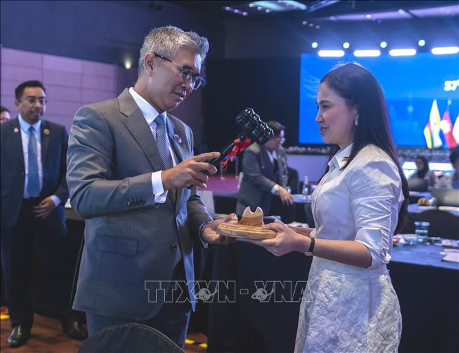 Bộ trưởng Thương mại, Đầu tư và Công nghiệp Malaysia Zafrul Abdul Aziz bàn giao nhiệm vụ Chủ tịch AEM cho đại diện Philippines, bà Dyah Roro Esti Widya Putri. Ảnh: TTXVN phát
