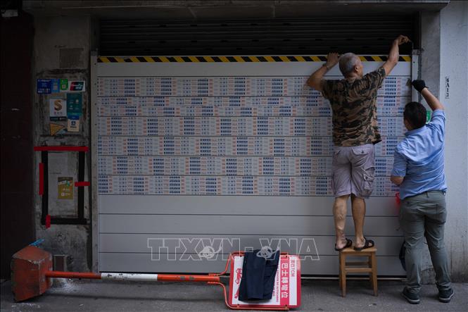 Người dân lắp rào chắn ngăn lũ tại Macau, Trung Quốc, trước khi bão Ragasa đổ bộ. Ảnh: THX/TTXVN