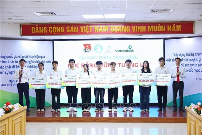 Bí thư Trung ương Đoàn, Chủ tịch Trung ương Hội Sinh viên Việt Nam Nguyễn Minh Triết cùng ông Nguyễn Danh Phương, Phó Bí thư Đảng ủy Ngân hàng TMCP Ngoại thương Việt Nam trao học bổng loại A cho học sinh, sinh viên. Ảnh: Minh Đức – TTXVN