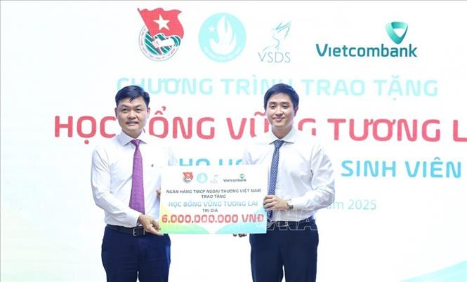 Ông Nguyễn Danh Phương, Phó Bí thư Đảng ủy Ngân hàng TMCP Ngoại thương Việt Nam trao bảng tượng trưng số tiền học bổng “Vững tương lai” cho Trung ương Hội Sinh viên Việt Nam. Ảnh: Minh Đức – TTXVN