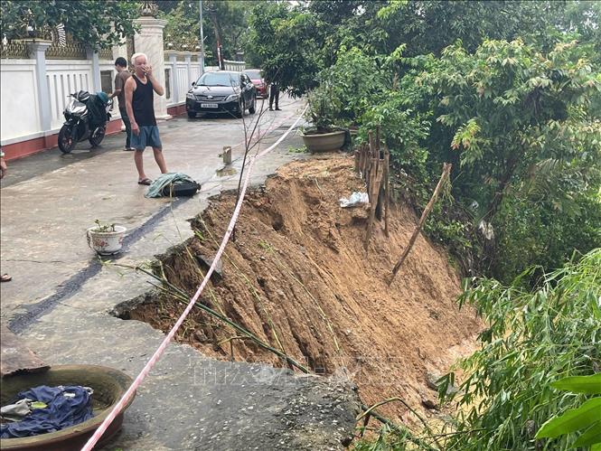 Tuyến đường bê tông nằm sát suối Chậm đoạn qua thôn Tân Giao có khoảng 3 điểm sạt lở, chiều cao cung sạt từ 6 - 7m, chiều sâu từ 3- 4m; điểm gần nhất của cung sạt chỉ cách tường bao nhà dân từ 2 - 4m. Ảnh: Khiếu Tư - TTXVN