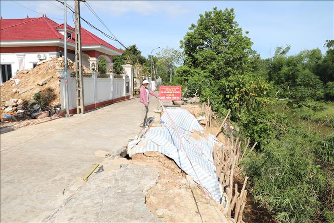 Chị Mai Thị Lợi, thôn Tân Giao, xã Thăng Bình lo lắng vì khoảng cách từ điểm sạt đến nhà chị chỉ cách khoảng 3m. Ảnh: Khiếu Tư - TTXVN