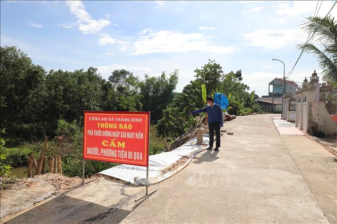 Sau khi xuất hiện điểm sạt, chính quyền địa phương đã gia cố tạm thời bằng cọc tre, đổ đất đá, chằng thép gai, phủ bạt và cắm biển cảnh báo, nhưng đây chỉ là giải pháp tạm thời. Ảnh: Khiếu Tư - TTXVN