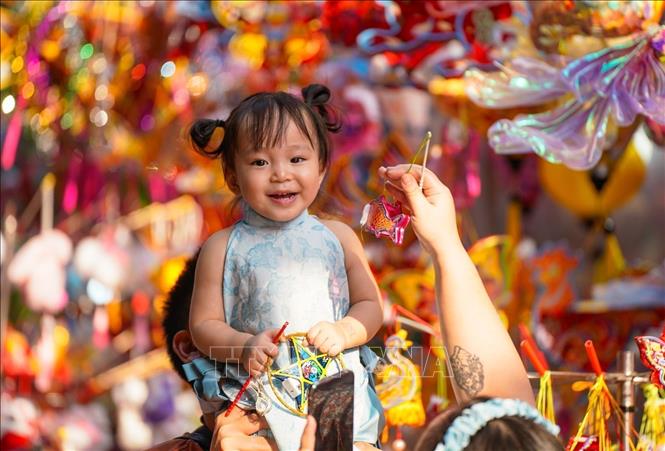 A child enjoys the colourful toys and festive ambiance at Hang Ma street. VNA Photo: Khánh Hoà