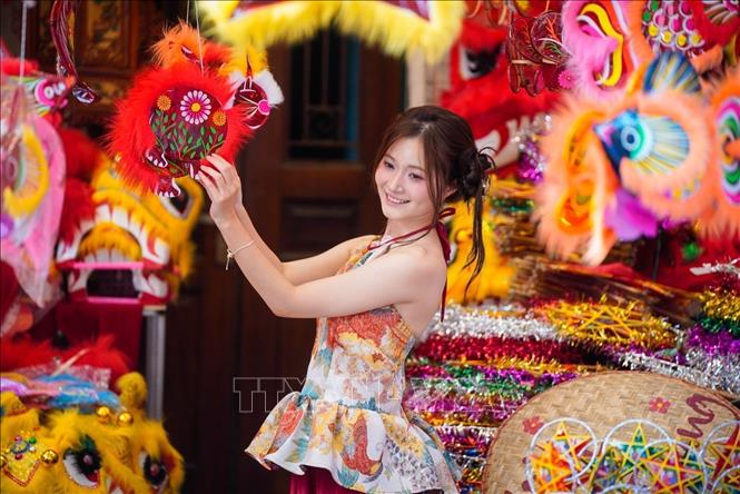 A visitor captures her moment with the festive atmosphere of Hang Ma street. VNA Photo: Khánh Hoà