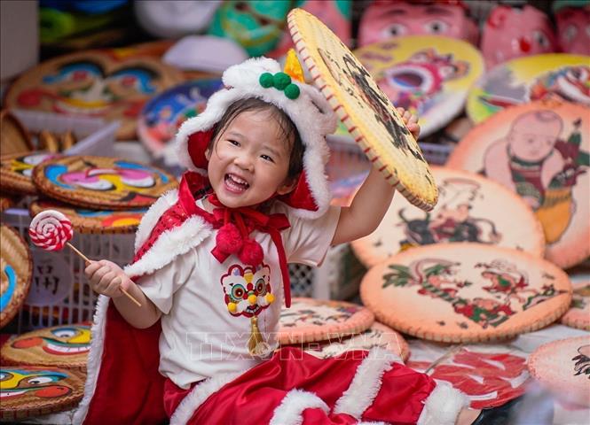 A child enjoys the colourful toys and festive ambiance at Hang Ma street. VNA Photo: Khánh Hoà