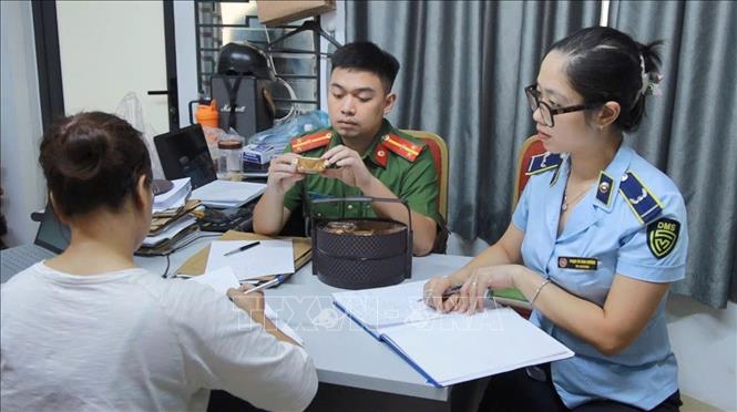 Lực lượng chức năng lập biên bản thu giữ hàng hóa không rõ nguồn gốc. Ảnh: Quốc Lũy - TTXVN