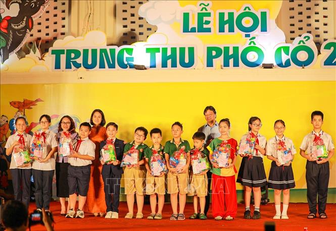 Đại diện UBND phường Hoàn Kiếm trao quà cho thiếu nhi có thành tích học tập xuất sắc. Ảnh: Khánh Hoà - TTXVN