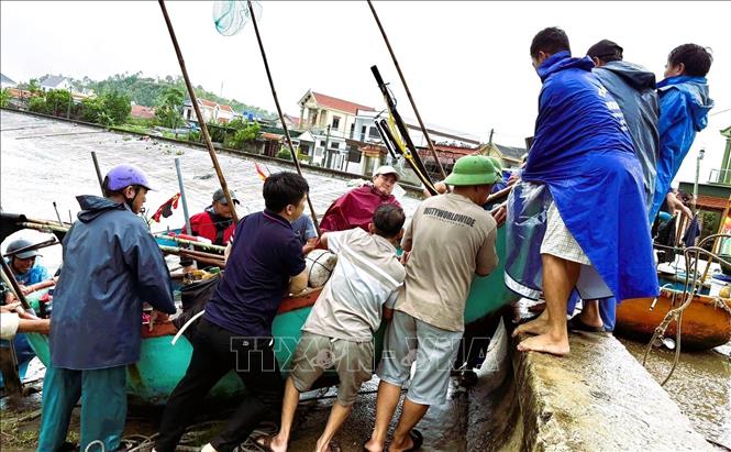 Sáng ngày 27/9, tại xã Quỳnh Phú (tỉnh Nghệ An), ngư dân làng biển đã hỗ trợ, giúp đỡ nhau đưa thuyền nhỏ, mủng và trang thiết bị, ngư lưới cụ vào nơi tránh trú. Ảnh: TTXVN phát