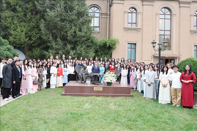 Cán bộ Đại sứ quán, đại diện cộng đồng và doanh nghiệp Việt Nam tại Bắc Kinh cùng các tân lưu học sinh tại Bắc Kinh dâng hoa tại tượng đài Bác Hồ trong khuôn viên Đại sứ quán. Ảnh: Công Tuyên-PV TTXVN tại Trung Quốc