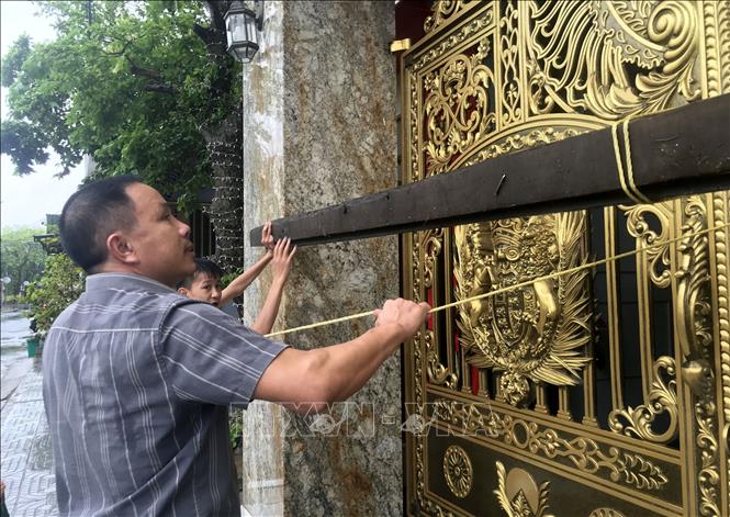 Người dân phường Cửa Lò (Nghệ An) chằng chống nhà cửa ứng phó bão số 10. Ảnh: Văn Tý-TTXVN