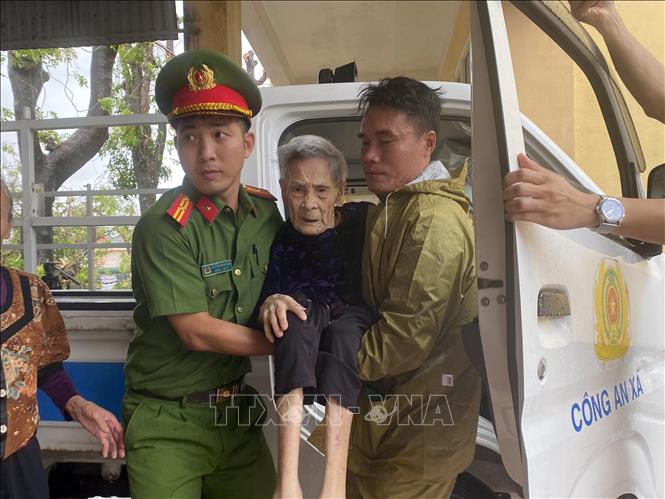 Lực lượng công an xã Đan Hải hỗ trợ đưa người dân đến nơi sơ tán. Ảnh: Hữu Quyết - TTXVN
