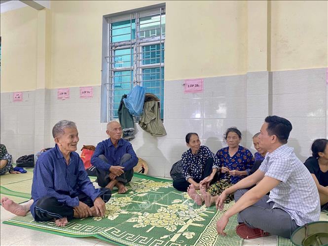 Lãnh đạo Đảng ủy xã Đan Hải thăm hỏi, động viên người dân tại điểm sơ tán. Ảnh: Hữu Quyết - TTXVN
