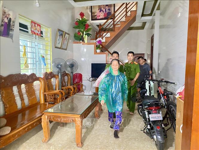 Lực lượng công an xã Đan Hải hỗ trợ đưa người dân đến nơi sơ tán. Ảnh: Hữu Quyết - TTXVN