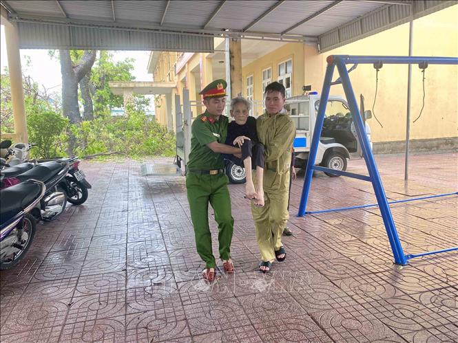 Lực lượng công an xã Đan Hải hỗ trợ đưa người dân đến nơi sơ tán. Ảnh: Hữu Quyết - TTXVN