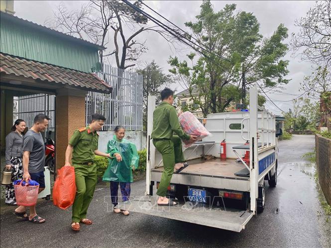 Lực lượng công an xã Đan Hải hỗ trợ đưa người dân đến nơi sơ tán. Ảnh: Hữu Quyết - TTXVN