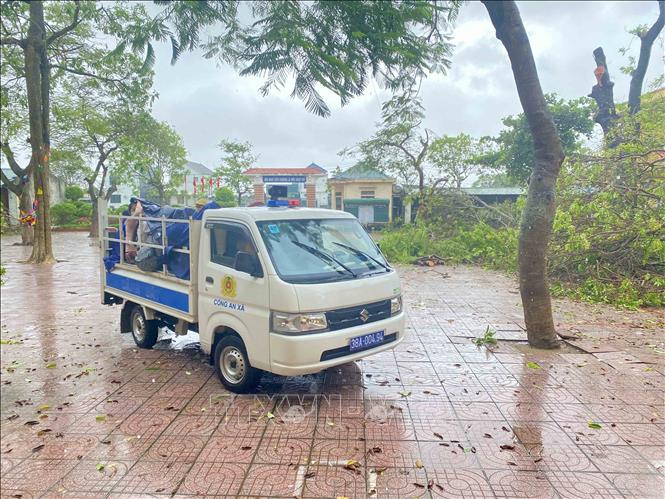 Lực lượng công an xã Đan Hải sử dụng xe ô tô để đưa người dân đến nơi sơ tán. Ảnh: Hữu Quyết - TTXVN
