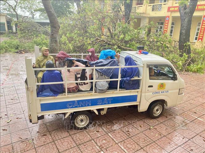 Lực lượng công an xã Đan Hải sử dụng xe ô tô để đưa người dân đến nơi sơ tán. Ảnh: Hữu Quyết - TTXVN
