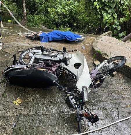Thi thể ông Phan Thanh P. cùng chiếc xe máy được lực lượng chức năng đưa lên bờ để bàn giao cho gia đình nạn nhân. Ảnh: TTXVN phát
