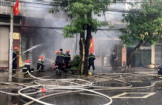 Lực lượng chức năng dập lửa, ngăn chặn đám cháy. Ảnh: Nguyễn Công Hải - TTXVN