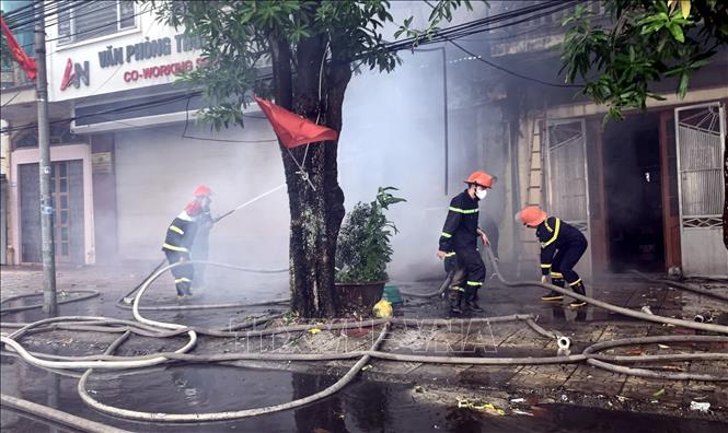 Lực lượng chức năng dập lửa, ngăn chặn đám cháy. Ảnh: Nguyễn Công Hải - TTXVN