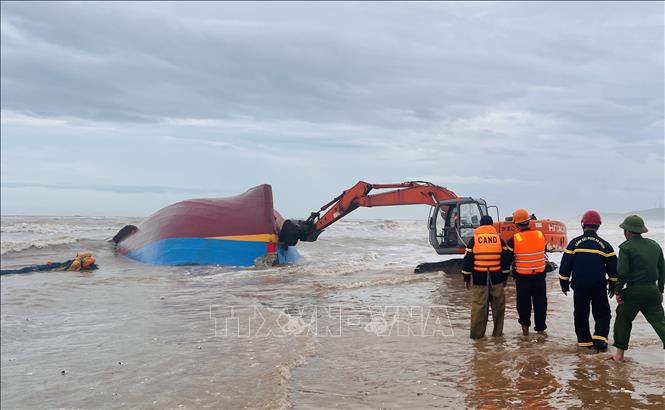 Phương án được thống nhất, lực lượng cứu hộ sử dụng xe múc để phá vỡ mui tàu, sau đó dùng xe cẩu chuyên dụng kéo toang các mảnh vỏ bằng dây cáp, tạo điều kiện tiếp cận khoang tàu bên trong tàu. Ảnh: Nguyên Linh-TTXVN