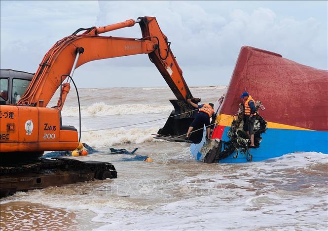 Phương án được thống nhất, lực lượng cứu hộ sử dụng xe múc để phá vỡ mui tàu, sau đó dùng xe cẩu chuyên dụng kéo toang các mảnh vỏ bằng dây cáp, tạo điều kiện tiếp cận khoang tàu bên trong tàu. Ảnh: Nguyên Linh-TTXVN