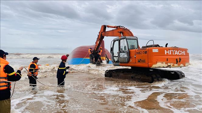 Xe máy múc được điều động đến hiện trường, thực hiện công tác cứu hộ, trục vợt tàu bị chìm. Ảnh: Nguyên Linh-TTXVN