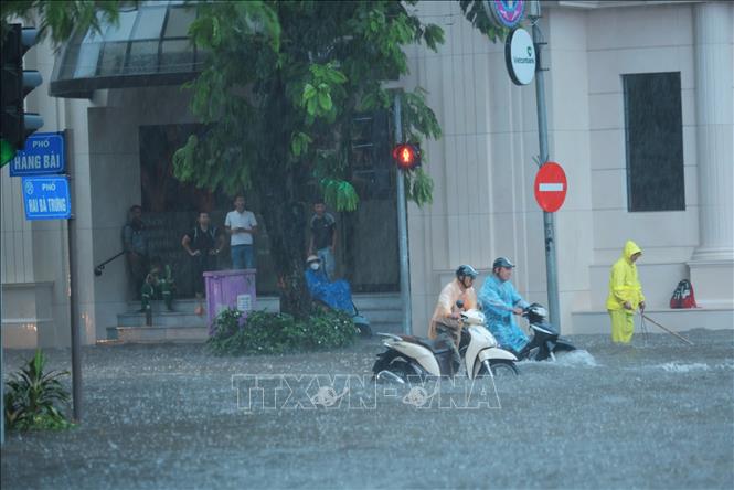 Nước ngập tới nửa thân xe máy trên phố Hàng Bài. Ảnh: Hoàng Hiếu-TTXVN