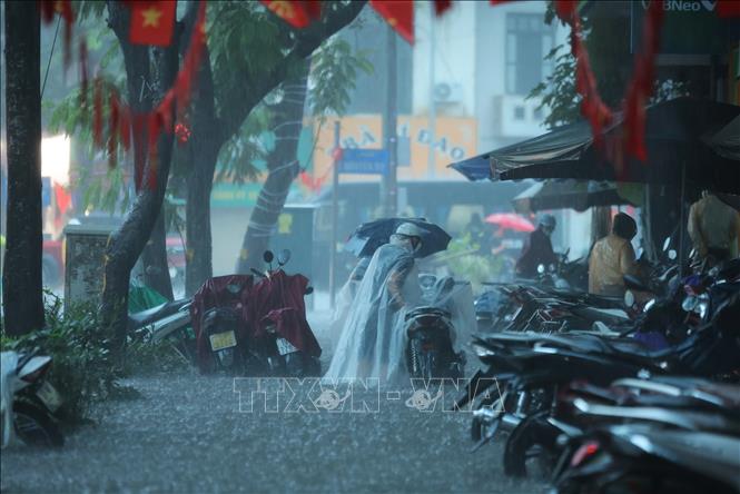 Nước ngập lênh láng trên hè phố Hai Bà Trưng. Ảnh: Hoàng Hiếu-TTXVN