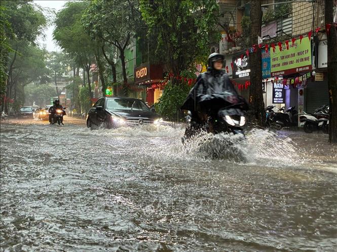 Đoạn phố Quán Thánh - Yên Ninh ngập sâu, các phương tiện di chuyển khó khăn. Ảnh: Lê Đông - TTXVN